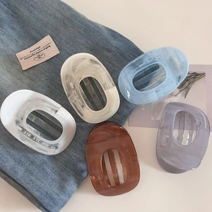 Détail de cinq pinces à cheveux ovales colorées sur fond de tissu en denim élégant