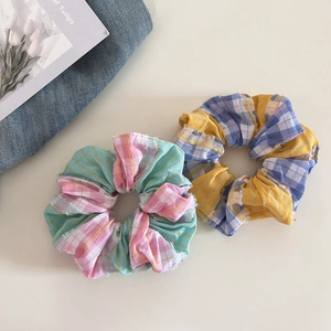 Macro detail of plaid hair scrunchies with frayed edges and golden metallic threads