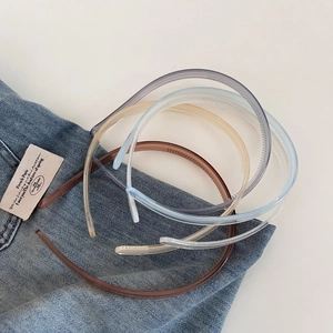 Detail showing non-slip teeth inside assorted jelly color plastic headbands on denim cloth