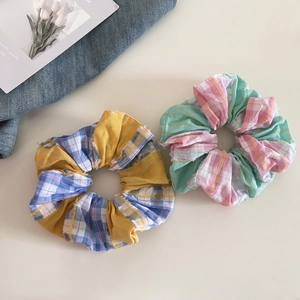 Detail of yellow and pink plaid fabric scrunchies with soft frayed edge textures
