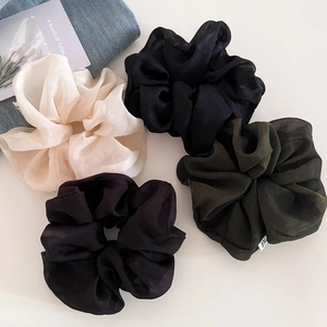 Detail showing set of four textured chiffon oversized scrunchies in neutral dark tones
