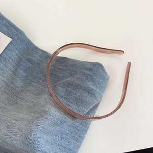 Detail view of amber jelly headband with non-slip teeth on blue denim background