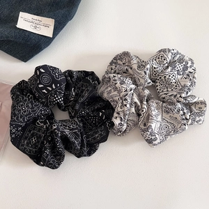 Close-up of black and white bandana paisley print scrunchies in soft vintage fabric