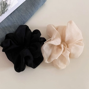 Detailed macro view of large textured chiffon scrunchies in black and beige colors
