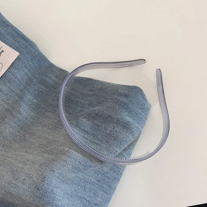 Close-up of translucent grey-purple headband with non-slip teeth on denim fabric