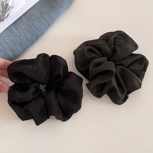 Macro detail of oversized black and olive green organza hair scrunchies set