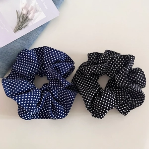 Close-up of navy blue and black polka dot scrunchies in lightweight chiffon fabric