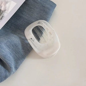 Détail d'une pince à cheveux minimaliste en résine blanc translucide au fini mat nuage