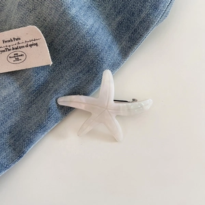Detail of starfish hair clip with pearlescent acetate finish on denim background