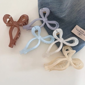 Flat lay of five sweet translucent bow hair claws in various elegant macaron colors