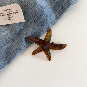 Detailed view of starfish hair clip with tortoiseshell pattern and silver metal fastener