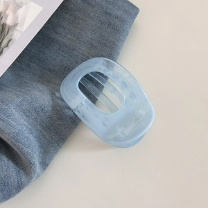 Gros plan d'une pince à cheveux bleu clair givrée sur un tissu en denim texturé