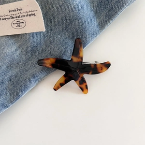 Detailed close-up of acetate starfish hair clip with vintage tortoiseshell texture and metal clasp
