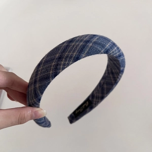 Detailed view of navy blue plaid padded headband with soft fabric texture and inner tag