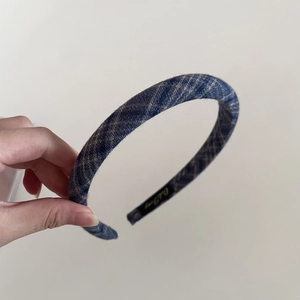 Close-up of a padded navy plaid headband featuring thickened sponge and vintage texture