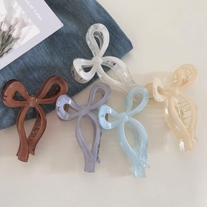 Detailed view of five colorful bow-shaped hair claws in smooth marble and pastel finishes
