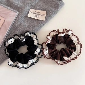 Detail of black and brown velvet scrunchies with intricate white lace edging decor