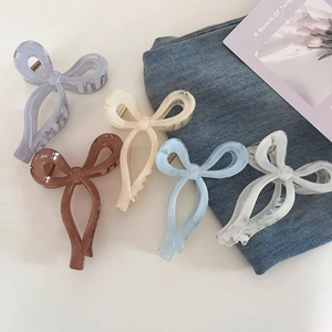 Sweet ribbon bow hair claws in various colors shown from a top-down aesthetic angle