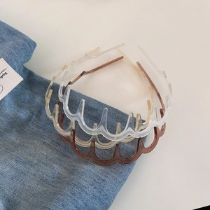 Three wave shaped non-slip hairbands in transparent, brown and beige on denim background