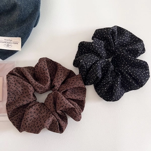 Detailed view of oversized leopard print scrunchies in brown and black chiffon fabric