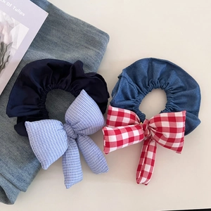 Detail of padded plaid bow hair ties in denim and navy fabrics for elegant ponytails