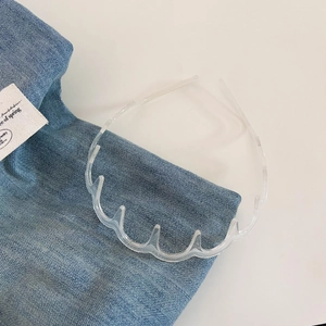 Detail of transparent wavy headband with anti-slip teeth placed on blue denim
