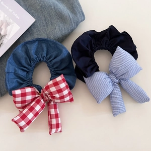Detail view of denim and navy blue oversized scrunchies with plaid ribbon bow ties