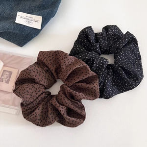 Oversized leopard print and spotted hair scrunchies on white background with denim