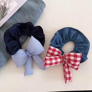 Detail of checkered padded bow scrunchies in navy blue and red denim cotton fabric