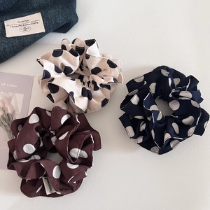 Detailed macro view of vintage polka dot scrunchies in cream navy and coffee fabric colors