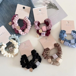 Minimalist colorful scrunchies set with geometric cubes and golden metal pendants