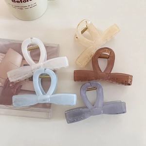 Vue à plat de cinq pinces à cheveux coréennes en forme de nœud en résine pastel