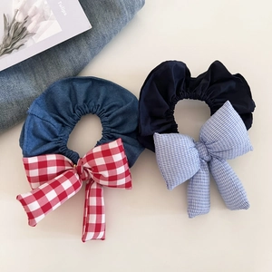Close-up of padded denim hair ties with blue and red gingham patterns and bows