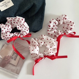 Three-piece set of red floral and polka dot fabric scrunchies with satin ribbon bows