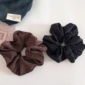 Detail view of oversized leopard print and speckled scrunchies in soft chiffon fabric