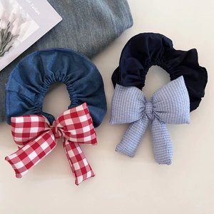 Detailed flat lay of denim scrunchies with plaid cotton bows on a soft background