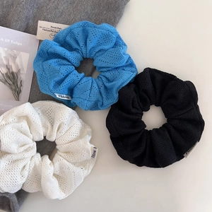 Détails de la texture tricotée des chouchous bleu, noir et beige avec étiquettes tissées