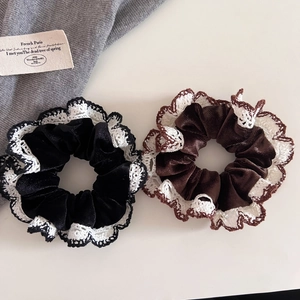 Detail of black and brown velvet scrunchies with white crochet lace trim in French style