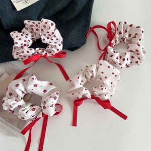 Detail of red floral and polka dot scrunchie set with long ribbon bows for hair styling