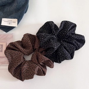 Flat lay of leopard print and polka dot oversized scrunchies on white background