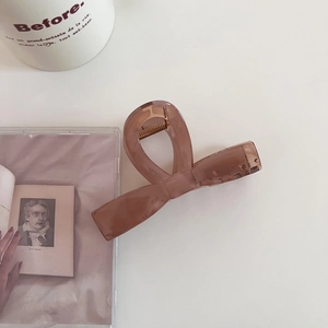 Détail d'une pince à cheveux nœud marron translucide avec mécanisme à ressort doré