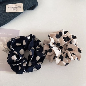 Vintage polka dot scrunchies in navy blue and cream white on white background