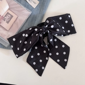 Macro detail of the retro black and white polka dot satin fabric on the hair claw clip