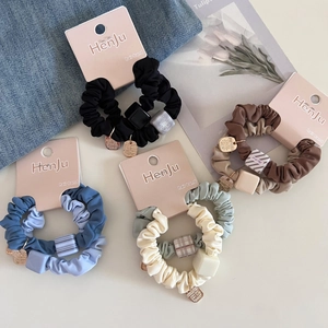 Detail of colorful scrunchies with resin cubes and metal charms in a stylish set