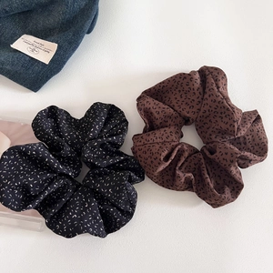 Close-up of leopard print and black floral fabric scrunchies for aesthetic hair styling