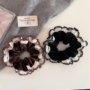 Detail of velvet scrunchies with white lace edges in black and chocolate brown