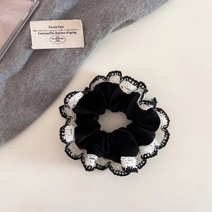 Detail shot of vintage black velvet hair scrunchie with crochet lace trim texture