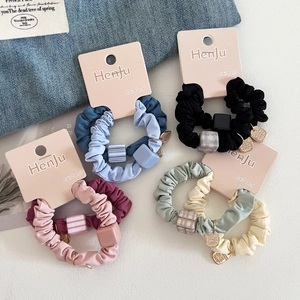 Detail of colorful scrunchies with square charms and gold tags in various stylish colors