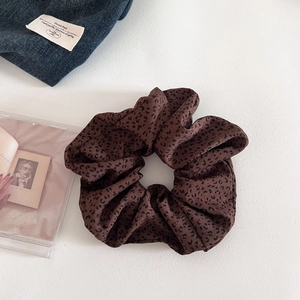 Detail of coffee leopard print scrunchie in soft chiffon fabric with elegant folds