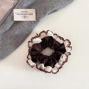 Detail of brown corduroy scrunchie with delicate white lace edge in French vintage style